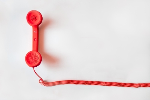 This is an image showing a red colored cable phone.